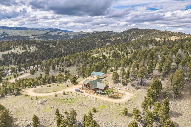 Aerial overview of property's location with a mountainous background and a forest | Image 13