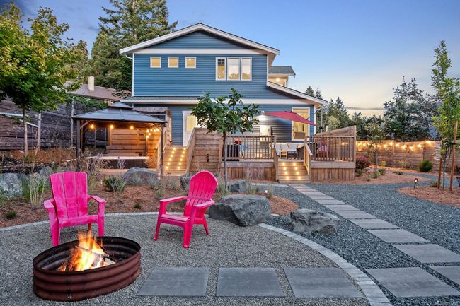Back of house at dusk featuring a gazebo, a deck, a patio area, and a fire pit | Image 4