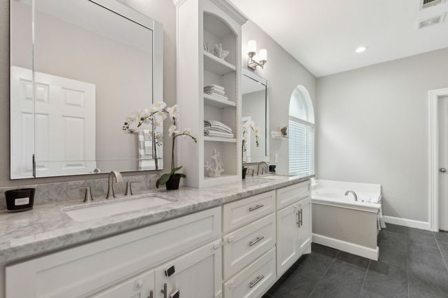 Bathroom with double vanity, a garden tub, and tile patterned flooring | Image 17
