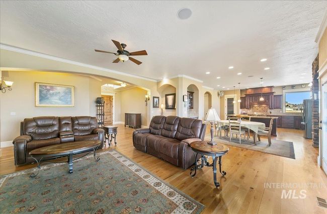 Living area featuring arched walkways, light wood-style floors, recessed lighting, ceiling fan, and a textured ceiling | Image 7
