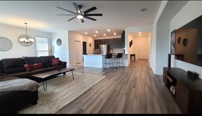 Living room with ceiling fan, wood finished floors, a chandelier, recessed lighting, and arched walkways | Image 23
