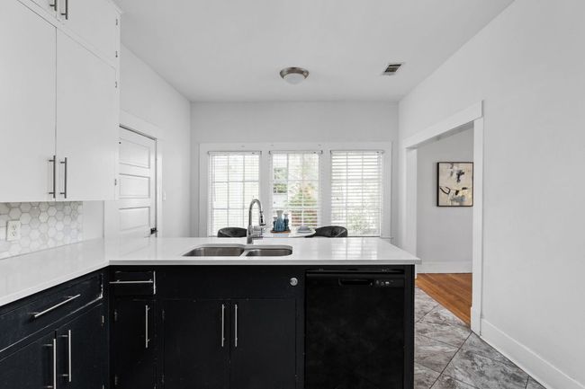 Kitchen featuring a sink, visible vents, dark cabinetry, and dishwasher | Image 12