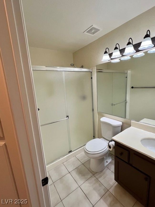Full bath featuring vanity, toilet, tile patterned floors, and a stall shower | Image 26