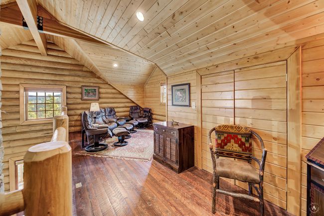 Sitting room featuring wooden ceiling, hardwood / wood-style flooring, lofted ceiling, rustic walls, and recessed lighting | Image 31