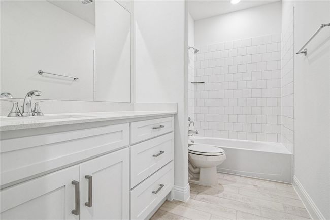 Bathroom featuring shower / bath combination, vanity, and wood tiled floors | Image 11