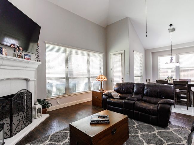The living room is filled with natural light and is open to both the dining and kitchen areas. | Image 10