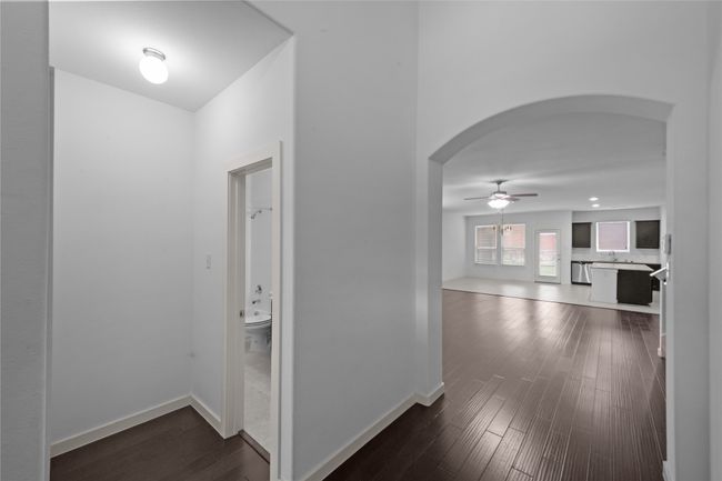 Hall with arched walkways and dark wood-style floors | Image 5