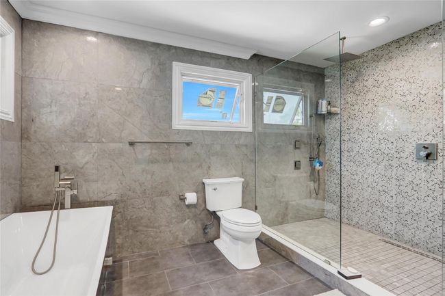Full bath with tile patterned flooring, a soaking tub, a shower stall, toilet, and tile walls | Image 18