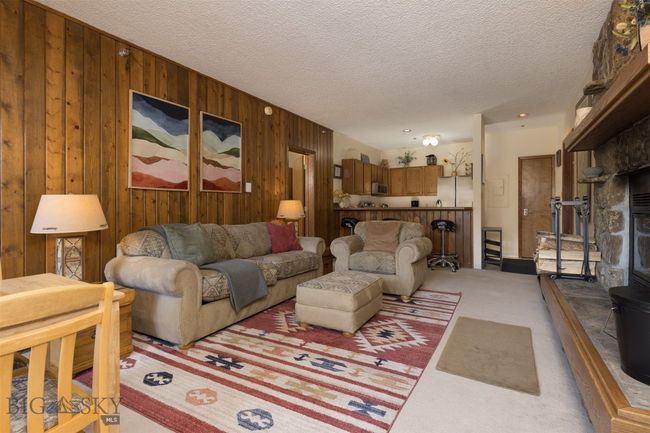 Living room featuring a textured ceiling, carpet floors, and wooden walls | Image 23