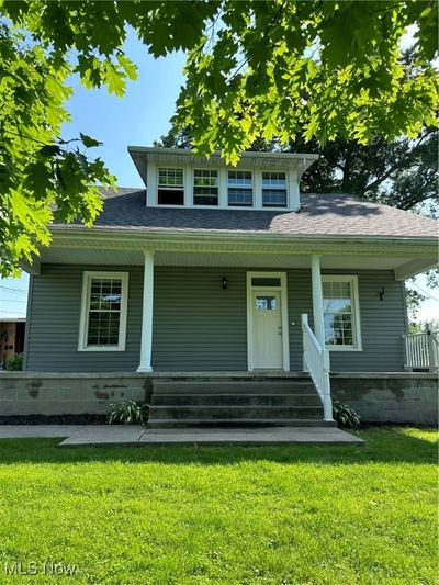 View of front facade with covered porch and a front yard | Image 1