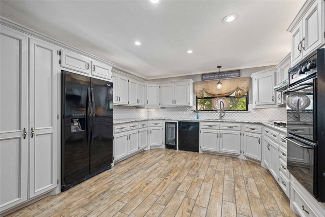 Kitchen featuring black appliances, backsplash, a sink, and recessed lighting | Image 15