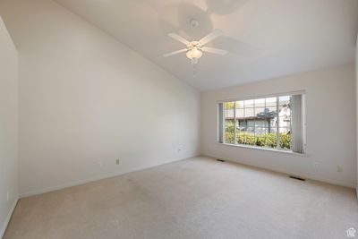 Spare room with lofted ceiling, light carpet, and ceiling fan | Image 2