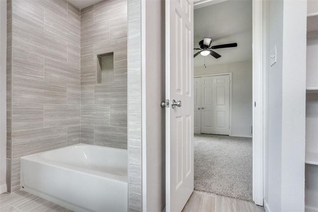 Bathroom featuring tub / shower combination and light wood-style floors | Image 21