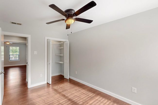Unfurnished bedroom with visible vents, a closet, baseboards, wood finished floors, and a ceiling fan | Image 28