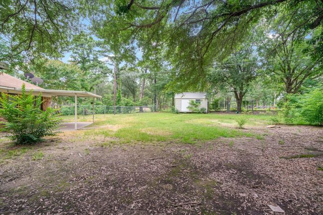 Fenced backyard featuring a storage unit and a patio area | Image 28