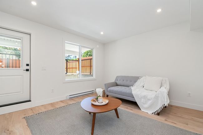 Living room featuring a baseboard heating unit, wood finished floors, and recessed lighting | Image 32