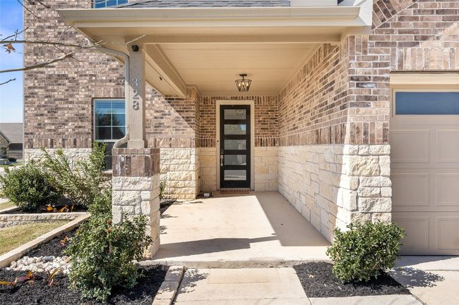Doorway to property with an attached garage and brick siding | Image 4
