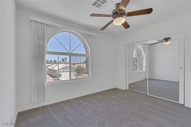Unfurnished bedroom with carpet flooring, ceiling fan, and a closet | Image 22