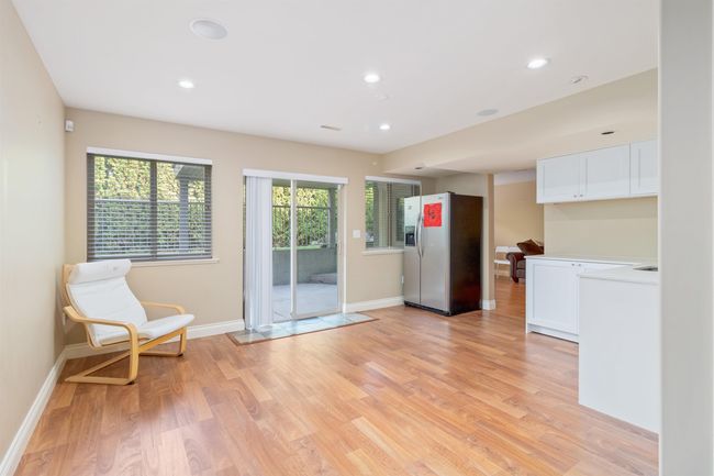Interior space featuring light wood-style floors, light countertops, stainless steel refrigerator with ice dispenser, and white cabinetry | Image 4