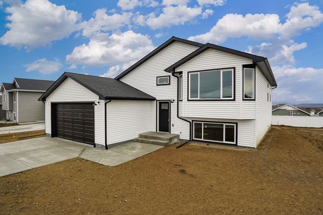 Tri-level home featuring fence, a garage, and driveway | Image 15
