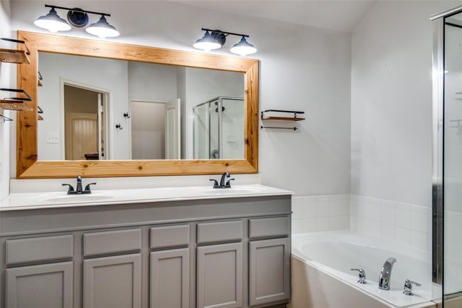 Full bath featuring a stall shower, a garden tub, and double vanity | Image 17