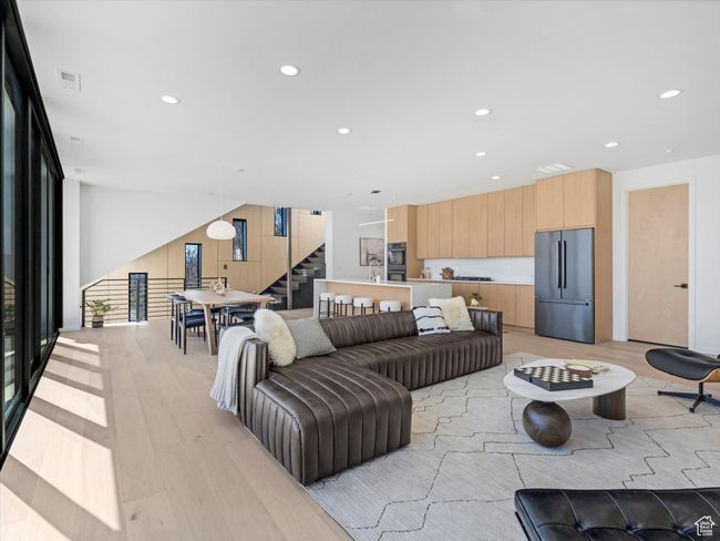 Living room featuring light wood-type flooring, recessed lighting, visible vents, and stairs | Image 16