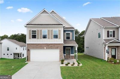 Craftsman-style house with a garage and a front lawn | Image 1