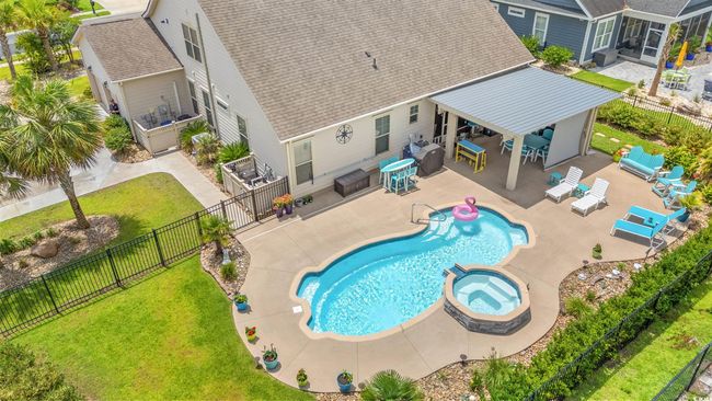 View of swimming pool featuring a pool with connected hot tub, a fenced backyard, a patio area, and outdoor lounge area | Image 4