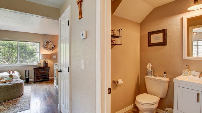 Half bath featuring healthy amount of natural light, vanity, wood finished floors, and a textured wall | Image 15