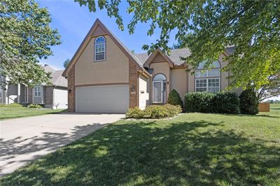 View of property with a garage and a front lawn | Image 2