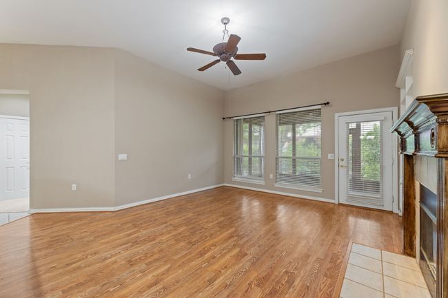 Unfurnished living room featuring a tile fireplace, light wood-style flooring, and a ceiling fan | Image 20