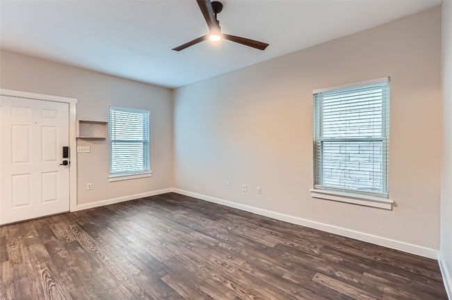 Unfurnished room featuring ceiling fan and dark wood finished floors | Image 5