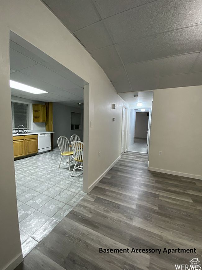 Hall with dark wood-type flooring, baseboards, a drop ceiling, and a sink | Image 40