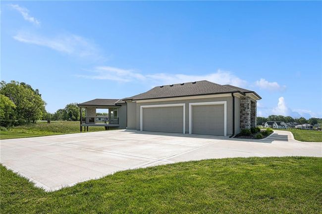 View of front of property with an attached garage, concrete driveway, a front lawn, and stucco siding | Image 7