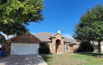 View of front facade featuring a front yard and a garage | Image 1