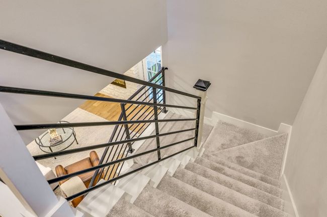 The stairwell features sleek iron horizontal railings that add a modern and sophisticated touch to the space. | Image 27