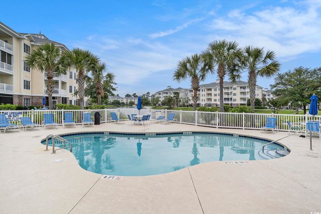 Community pool with fence and a patio | Image 17