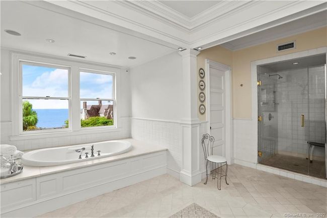 PRIMARY SUITE // One of two full baths with gas fireplace, custom cabinetry, limestone counter and flooring and Waterworks fixtures. | Image 18