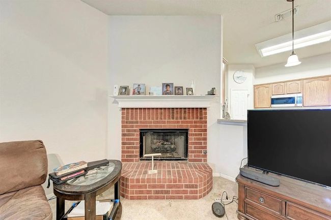 Carpeted living area featuring a fireplace | Image 7