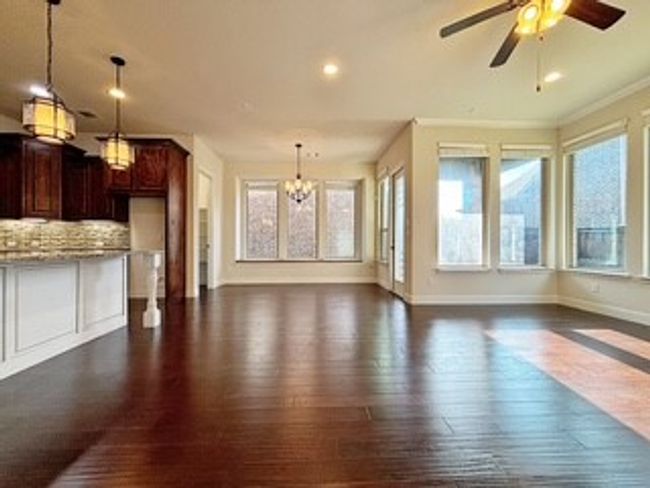 Unfurnished living room featuring a chandelier, dark wood-style floors, a ceiling fan, and recessed lighting | Image 9
