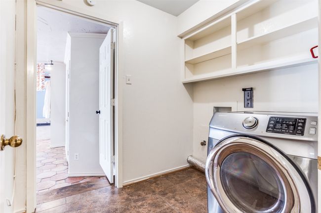 Clothes washing area with washer / dryer, baseboards, and dark stone finish floors | Image 18