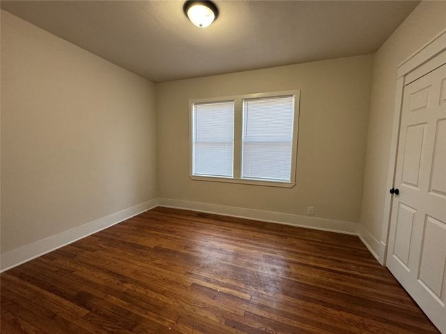 Unfurnished bedroom featuring dark wood finished floors and baseboards | Image 4