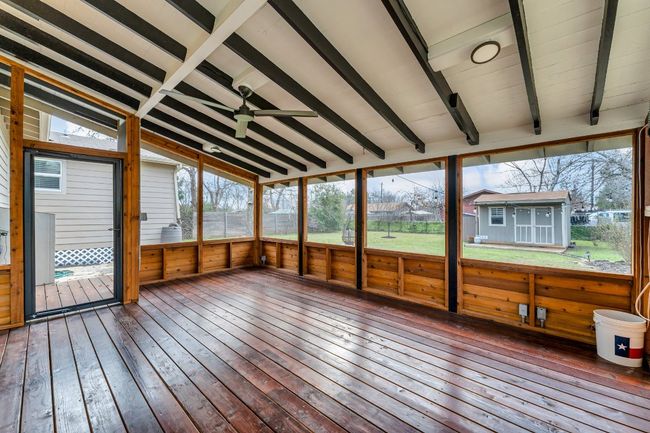 Huge screened in sunroom with vaulted ceiling with beams and ceiling fan. | Image 22