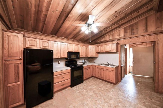 Step inside the garage apartment where you'll find the same incredible cedar ceiling as the main home. This efficiency features new appliances and all convey with the sale of the home. | Image 22