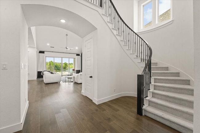 Stairs with a ceiling fan, arched walkways, wood finished floors, and recessed lighting | Image 4