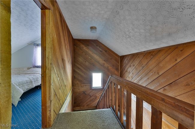 lofted ceiling, wooden walls, plenty of natural light, and an upstairs landing | Image 22