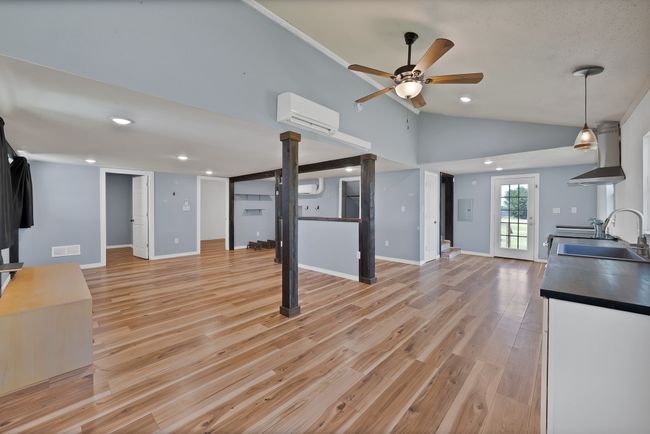 Unfurnished living room with ceiling fan, a wall mounted air conditioner, light wood-style floors, lofted ceiling, and recessed​​‌​​​​‌​​‌‌​‌‌​​​‌‌​​‌‌​‌​​​​​‌ lighting | Image 4