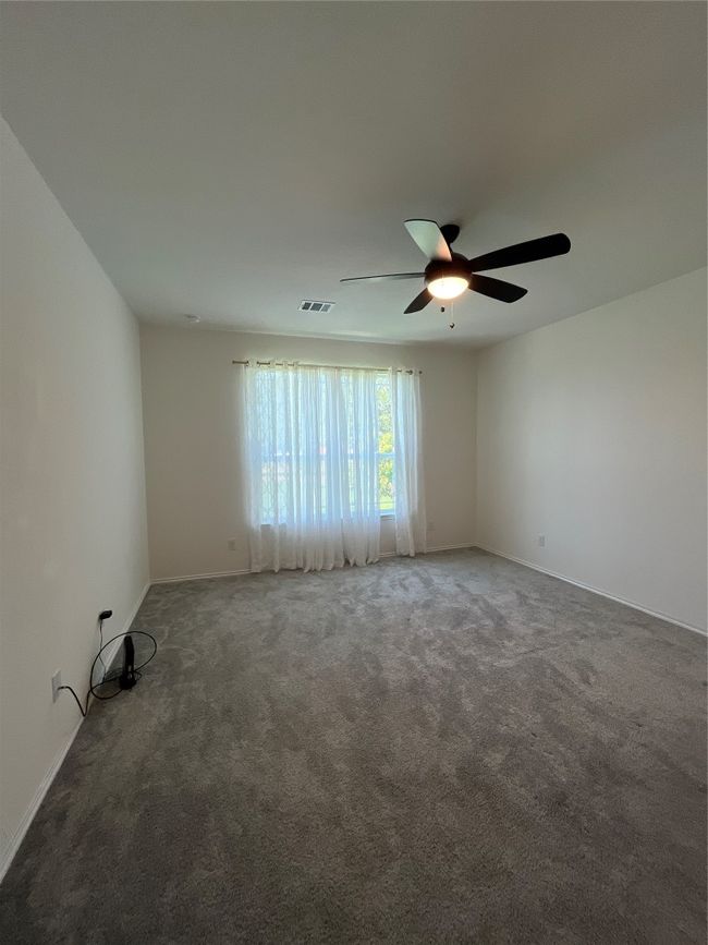 Empty room with baseboards, a ceiling fan, carpet flooring, and visible vents | Image 13