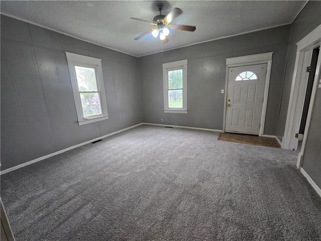 Entrance foyer featuring healthy amount of natural light, a ceiling fan, a textured ceiling, carpet floors, and ornamental molding | Image 24