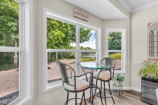 dining room featuring ornamental molding, vinyl plank flooring and a water view | Image 24